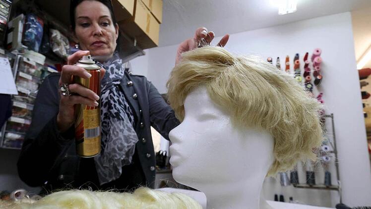 Noch hat diese Perücke wenig Ähnlichkeit mit den Haaren von Donald Trump. Aber Manuela Plank, Eigentümerin eines Kostumverleihs, hilft mit Farbe kräftig nach.  Foto: Ronald Zak, dpa