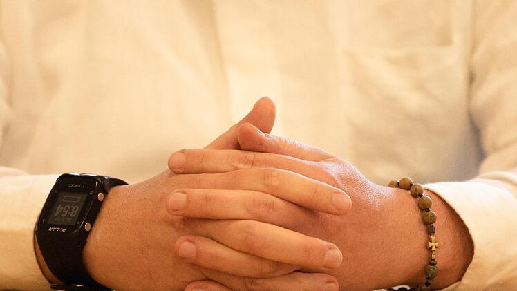 Der angeklagte Priester trägt im Gerichtssaal ein Armband mit einem Kreuz.  Foto: Nicolas Armer, dpa