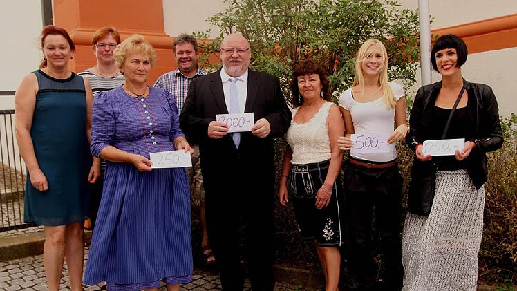 Unser Bild zeigt Theaterspieler mit den Spendenempfängern (von links): Magda Stöhr, Tanja Wissendheit, Mechtild Kirchner (Oskar-Kandler-Zentrum), Roland Gehring, Pfarrer Martin Wissel (Kirchengemeinde), Leiterin Marianne Baum und Jennifer Baum (IHADG Kirchlauter) und Kerstin Göpfert (Kindergarten Kirchlauter). Foto: Günther Geiling