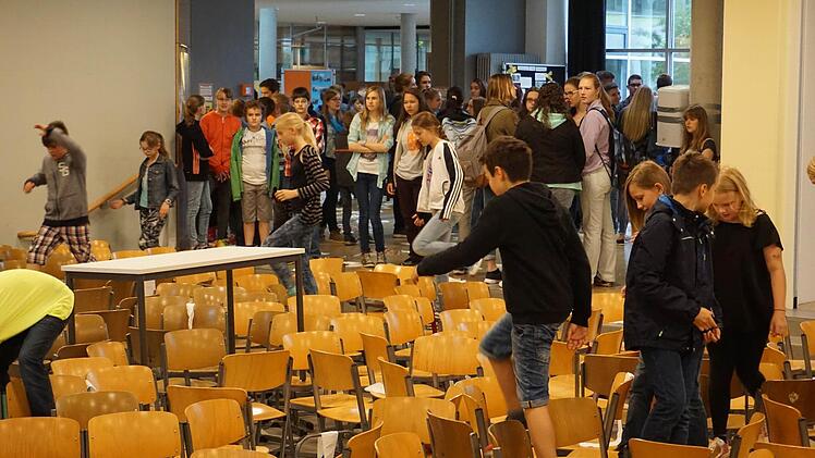 Die Schüler klettern über hunderte Stühle, die in der Aula zusammengetragen wurden. Foto: Tina Meier