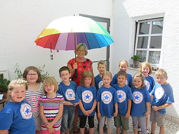 Ulli Berninger mit Kindern unter dem Regenschirm. Foto: Philipp Bauernschubert