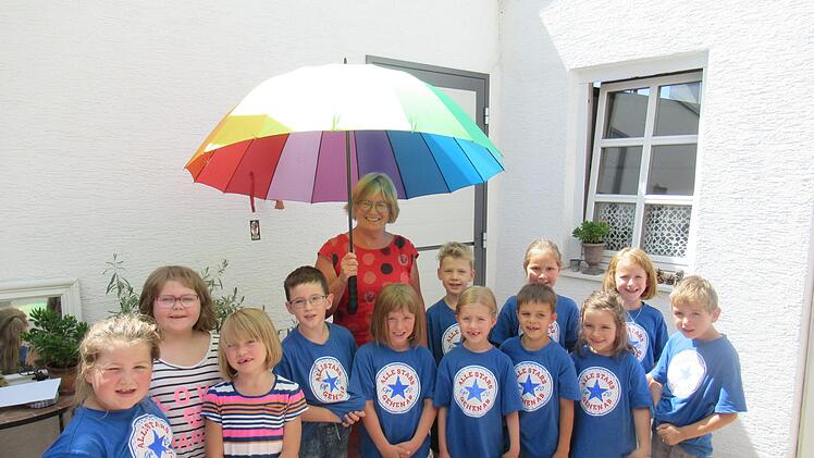 Ulli Berninger mit Kindern unter dem Regenschirm. Foto: Philipp Bauernschubert