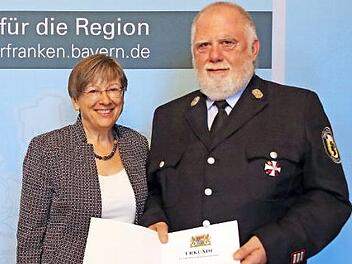 Regierungspräsidentin Heidrun Piwernetz hat Thomas Döll Ehrenurkunde und Steckkreuz ausgehändigt.  Foto: Michael Weiser, Regierung von Oberfranken