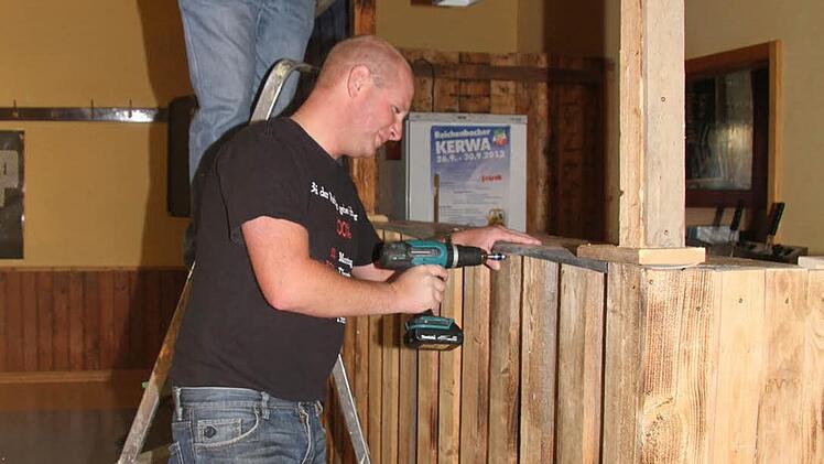 Martin Unkauf und Tobias Spindler ziehen die letzten Schrauben an der neuen Essens- und Getränkeausgabe im Burschenheim fest. Foto: Sonja Adam