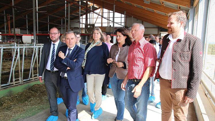 Landwirt Volker Schunk (rotes Hemd) f&uuml;hrte Martin Mittag, Landwirtschaftsministerin Michaela Kaniber, Birgit Weber, Michael Schulz und Sebastian Straubel (von rechts) durch seinen Stall. Jannik Reutlinger