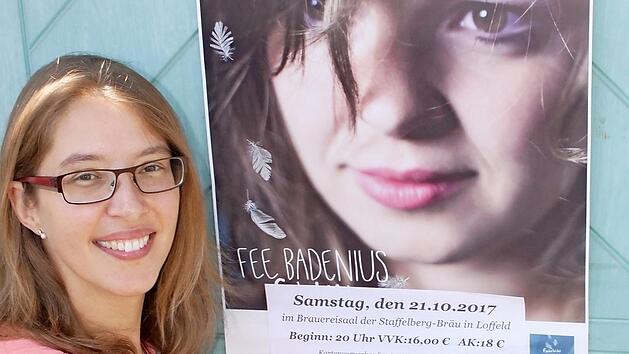 Tanja Dowerg beim Anbringen eines Plakats zum Auftritt von Fee Badenius in Loffeld. Foto: Matthias Einwag