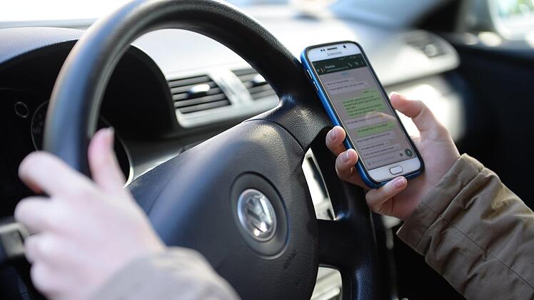 Nicht nur das Tippen auf dem Handy lenkt Fahrer ab. Symbolbild: Monika Skolimowska/dpa