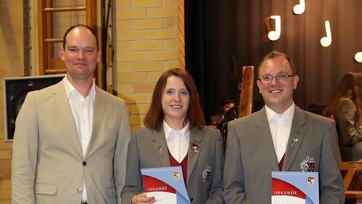 Ehrennadel in Silber für 20 Jahre aktives Musizieren (von links):  Mario Hugo (NBMB) zeichnet Silvia Albert und Timo-Jan Deen aus. Foto: Heiko Grappendorf.