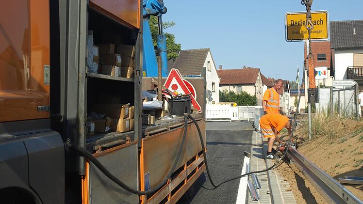 Rechts und links der Zufahrt zur Bahnbrücke bauen Fachkräfte noch Leitplanken ein. Foto: Stefan Geiger