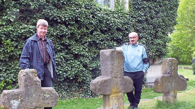 Als Manfred Welker (l.) und Helmut Fischer Anfang Mai die Steinkreuze im Schlossgraben begutachteten, standen noch alle drei Exemplare an ihrem Platz. In der Zwischenzeit wurde das Kreuz rechts von Unbekannten beschädigt und ist eingelagert. Foto: privat