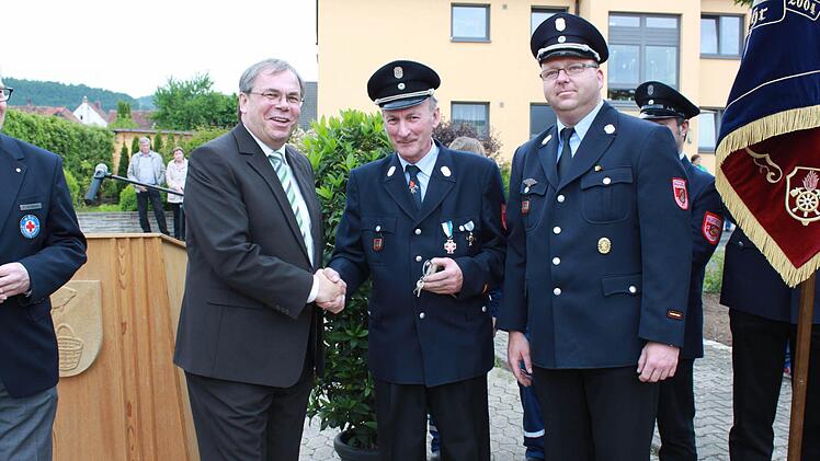 Sands Bürgermeister Bernhard Ruß (links) überreicht die Schlüssel für den Erweiterungsanbau den beiden Kommandanten Lothar Mühlfelder (Mitte) und Andreas Winkler.  Fotos: Alfons Beuerlein