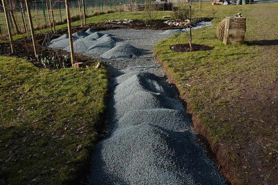 Während im ersten Terrassenbereich der Boden gelegt wird, warten im zweiten bereits die Splitthäufchen auf ihren Einsatz.