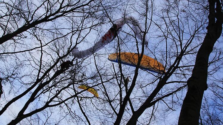 Während die Bergwacht den Schirm aus den Ästen befreite, flogen die anderen Paraglider über dem Wald munter weiter. Fotos: Ralf Ruppert