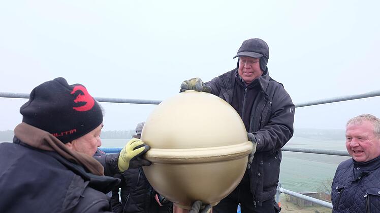 Eisige Temperaturen herrschten bei der Installation der Kugel mit Eisenkreuz und Wetterhahn auf dem neu eingedeckten Kirchturm der Kirche St. Matthias in Theinfeld. Foto: Philipp Bauernschubert