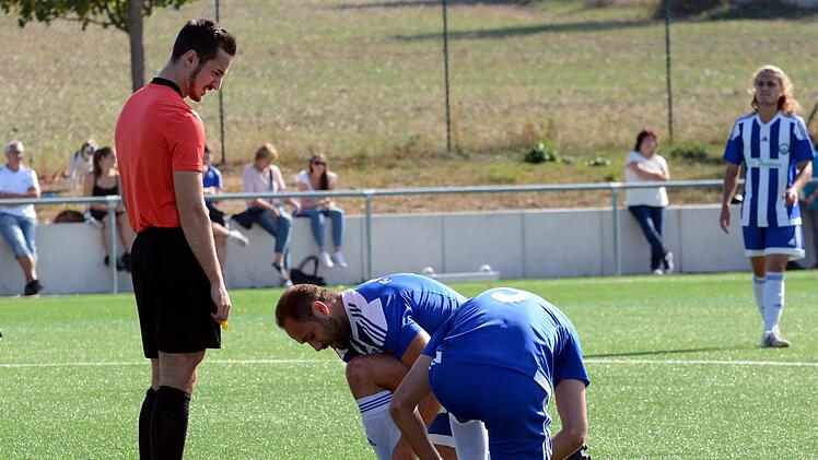 Regel 08/15: Schiedsrichter Patrick Höfer überwacht den korrekten Ablauf des Schuhebindens bei  Spielern der Bezirksliga Mittelfranken 1. Foto: herzopress