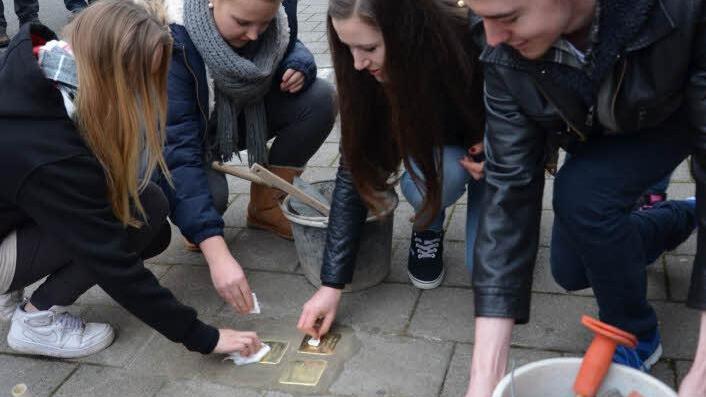 Die drei neuen Stolpersteine wurden vond en Schülern poliert.