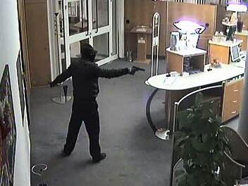 Das Bild der Überwachungskamera zeigt einen der Täter während des Überfalls in der Ebensfelder Sparkassenfiliale. Foto: Polizei