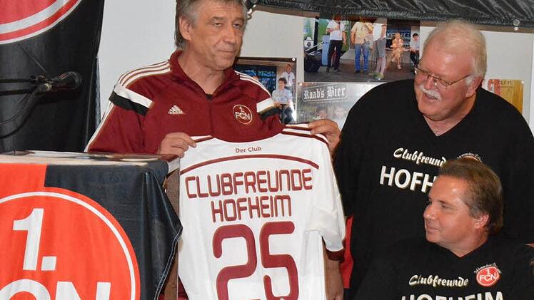 Fanbeauftragter Jürgen Bergmann (links) überreichte an die Clubfreunde Hofheim ein Jubiläumstrikot und zeichnete Gerhard Rectanus (rechts) mit der Ehrennadel in Gold des 1. FC Nünberg aus. Sitzend davor ist Zweiter Vorsitzender Georg Butterhof.  Foto: Gerhard Schmidt