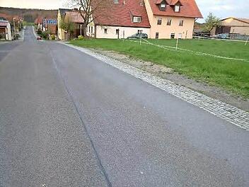 An manchen Stellen in dem Königsberger Stadtteil Hofstetten fehlen am Rand der Ortsdurchfahrtsstraße Gehstreifen. Die Bürger finden, dass dies besonders für Kinder eine große Gefahr darstellt. Foto: Gerold Snater