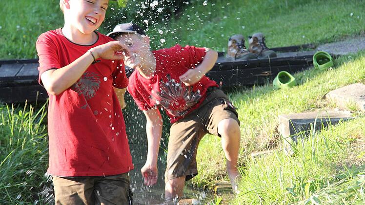 Fritz (links) und sein Freund Luca spielen gerne am Bach, bauen Dämme oder spritzen sich an heißen Tagen gegenseitig nass. Fotos: Angelika Silberbach