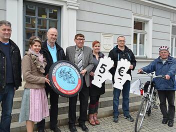 Dieter Maisel (Aral-Tankstelle), Katrin Uano, Gerald Brehm, Helmuth Schuh, Swenja Ott und Daniel Chmarra (Aral-Tankstelle) trafen auf dem Marktplatz Werner Geier (v. l.), der auf die kleine Versammlung aufmerksam wurde und in diesem Jahr unbedingt mitradeln will. Foto: Larissa H&auml;ndel