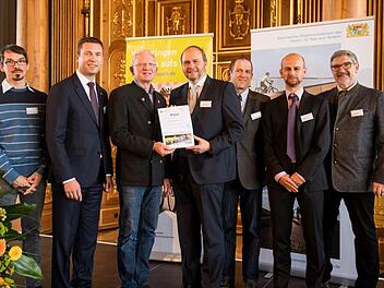 So sehen Sieger aus: Auch Michael Busch (rechts) als stellvertretender Vorsitzender der AGFK Bayern freute sich &uuml;ber den Sieg der Gemeinde Ebersdorf b.Coburg. Foto: AGFK Bayern