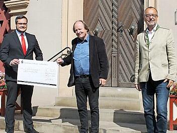 Sparkassenleiter Michael Schmelzer (von links), Intendant des Fr&auml;nkischen Theatersommers Jan Burdinski und Erster B&uuml;rgermeister J&uuml;rgen Kohmann bei der Scheck&uuml;bergabe vor dem Rathaus. Foto: privat