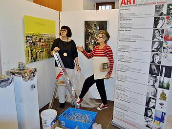 Die Bad Kissinger Künstlerinnen Silvia Pfister-Stanjek (links) und Eva Feichtinger beim Ausstellungsumbau vor Werken ihres Kollegen Alexander Ruppert. Foto: Sigismund von Dobschütz