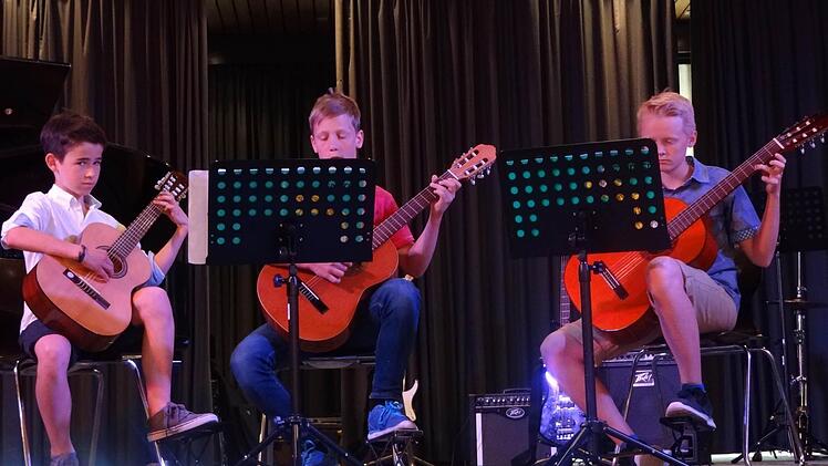 An der Gitarre, einem sehr beliebten Saiteninstrument: Nico Rößner, Moritz Werner und Hannes Rödel.