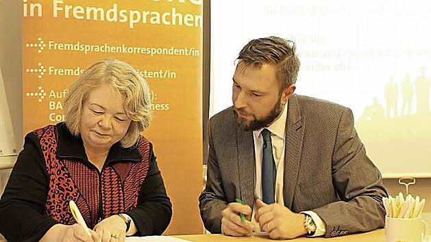 Petra Bagley von der University of Central Lancashire und Asco-Leiter Matthias Schmidt-Curio unterzeichnen den Kooperationsvertrag in der Coburger Sprachenschule. Foto: Ulrike Nauer