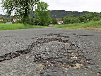 An vielen Stellen muss die Straße zwischen Feldbuch und Rugendorf (im Hintergrund) saniert werden, um noch größere Schäden zu vermeiden. Foto: Matthias Beetz