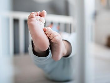 Baby in Gitterbett
