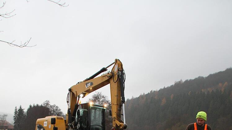 Zwei Bauarbeiter pflastern einen Regenablauf am Rande der neu gebauten Straße. Foto: Ulrike Müller