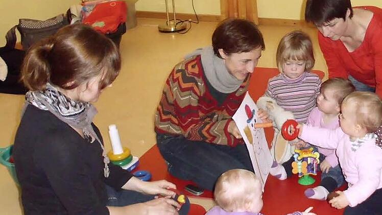 Janet Bauduin (Zweite von links) lehrt Eltern und Kinder die Zwergensprache: Auch Anna Hasselbach (mit Alena), Karin Dotterweich (mit Klara), und Steffen Oldiges (mit Mina) setzen auf diese Form der frühen Kommunikation.
