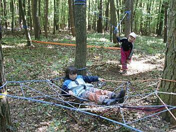 Aus Seilen wurde ein Netz zwischen drei Bäume gewebt, in dem Lea ihre Pause genießt. Foto: sw