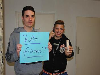 Ahmad (links), dessen Unterschenkel zerschossen wurde und in dem noch ein Splitter steckt, und Hassan zeigen, dass es in den Räumen im Erdgeschoss ziemlich kühl ist. Foto: Ralf Kestel