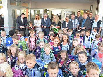 Die Schüler können es kaum erwarten, endlich in die frisch sanierte Emil-Fischer-Grundschule in Dörfles-Esbach einziehen zu dürfen. Doch erst muss noch das Band durchgeschnitten werden. Rainer Lutz