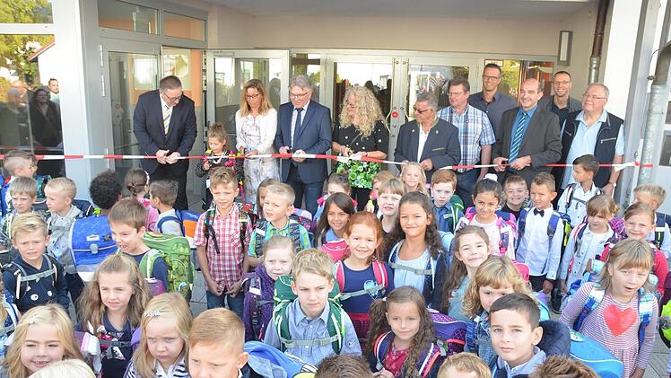 Die Schüler können es kaum erwarten, endlich in die frisch sanierte Emil-Fischer-Grundschule in Dörfles-Esbach einziehen zu dürfen. Doch erst muss noch das Band durchgeschnitten werden. Rainer Lutz