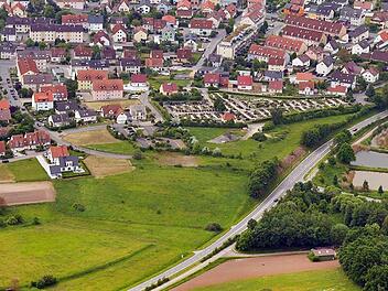 An der Einmündung des Lerchenwegs (rechts, bei den Weihern) soll ein Kreisverkehr gebaut werden. Von dort soll eine Straße zu den Einkaufsmärkten (ganz am linken Bildrand unten) führen. Die Aufnahme entstand vor Beginn der Erweiterungsarbeiten am Friedhof. Foto: Ronald Rinklef