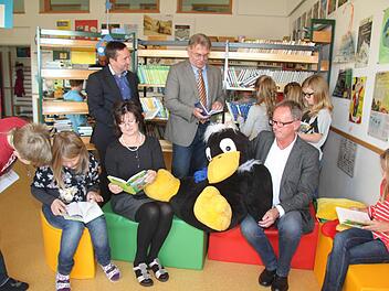 Alles ist neu in der Schulbücherei: Die Kinder sind begeistert von der großzügigen Spende, die Maria und Reinhard Ultsch (sitzend) getätigt haben. Endlich sind die neuesten Bücher vorhanden. Und Bürgermeister Norbert Gräbner (hinten links) brachte die frohe Botschaft mit, dass zwei Tablets bewilligt sind. Damit können die Kinder das Antolin-Leseförderungsprogramm via Tablet direkt nutzen. Auch Schulrat Uwe Dörfer (hinten, Zweiter von links) freute sich über die Neuerungen. Fotos: Sonja Adam