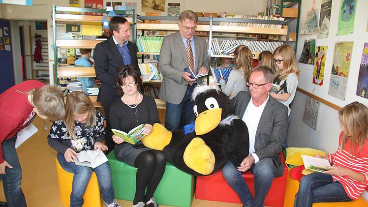 Alles ist neu in der Schulbücherei: Die Kinder sind begeistert von der großzügigen Spende, die Maria und Reinhard Ultsch (sitzend) getätigt haben. Endlich sind die neuesten Bücher vorhanden. Und Bürgermeister Norbert Gräbner (hinten links) brachte die frohe Botschaft mit, dass zwei Tablets bewilligt sind. Damit können die Kinder das Antolin-Leseförderungsprogramm via Tablet direkt nutzen. Auch Schulrat Uwe Dörfer (hinten, Zweiter von links) freute sich über die Neuerungen. Fotos: Sonja Adam