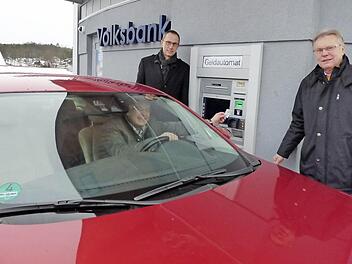 Bürgermeister Hanngörg Zimmermann hebt Geld ab, während er in seinem Auto sitzt.  Foto: Thomas Weichert