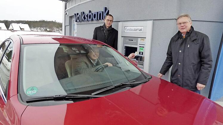 Bürgermeister Hanngörg Zimmermann hebt Geld ab, während er in seinem Auto sitzt.  Foto: Thomas Weichert