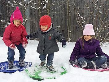 Elsa, Jules und Madelaine von der Insel La Réunion im indischen Ozean machten in der Rhön ihre ersten Erfahrungen mit der weißen Pracht - und stellten fest, dass man auf dem Rutschschlitten auch "Surfen" kann.  Fotos: privat