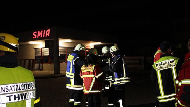Nächtliche Einsatzbesprechung der Feuerwehren vor der Einfahrt zum Gelände des Automobilzulieferers SMIA in Michelau Foto: Ramona Popp