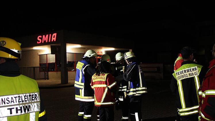 Nächtliche Einsatzbesprechung der Feuerwehren vor der Einfahrt zum Gelände des Automobilzulieferers SMIA in Michelau Foto: Ramona Popp