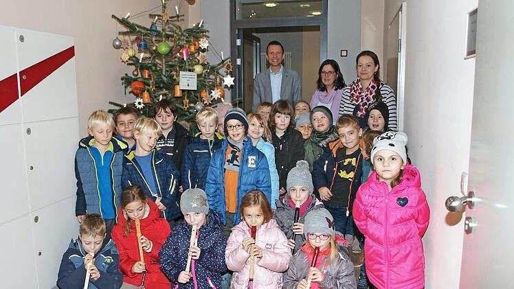 Die Schüler der Klasse 1a der Grundschule am Markt schmückten diesmal den Weihnachtsbaum im Rathaus II der Stadt. Dafür bedankte sich Bürgermeister Andreas Hügerich bei den Schülern, der Rektorin Michaela Schell und der Klassenleiterin Eva-Maria Kundmüller (hinten von links). Foto: Alfred Thieret