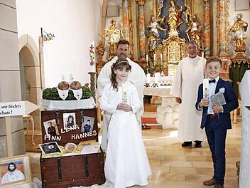 Lena Roos und Finn Kotschenreuther gingen in der Pfarrkirche St. Johannes der Evangelist zum ersten Mal zum Tisch des Herrn. Mit im Bild Pfarrvikar Anton Heinz (links) und Helmut Müller (Kirchenpfleger und Wortgottesdienstleiter).  Foto: K.- H. Hofmann
