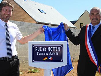 Mottens Bürgermeister Jochen Vogel und Jean-Luc Adelaide, Bürgermeister von Ranville, enthüllen das Schild. Fotos: Birgit Will