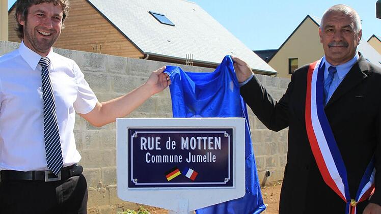 Mottens Bürgermeister Jochen Vogel und Jean-Luc Adelaide, Bürgermeister von Ranville, enthüllen das Schild. Fotos: Birgit Will